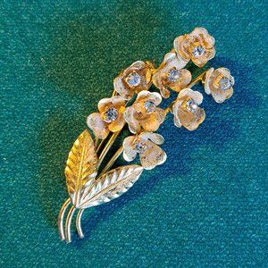 Vintage 8 flower gold tone rhinestone signed Triad brooch.